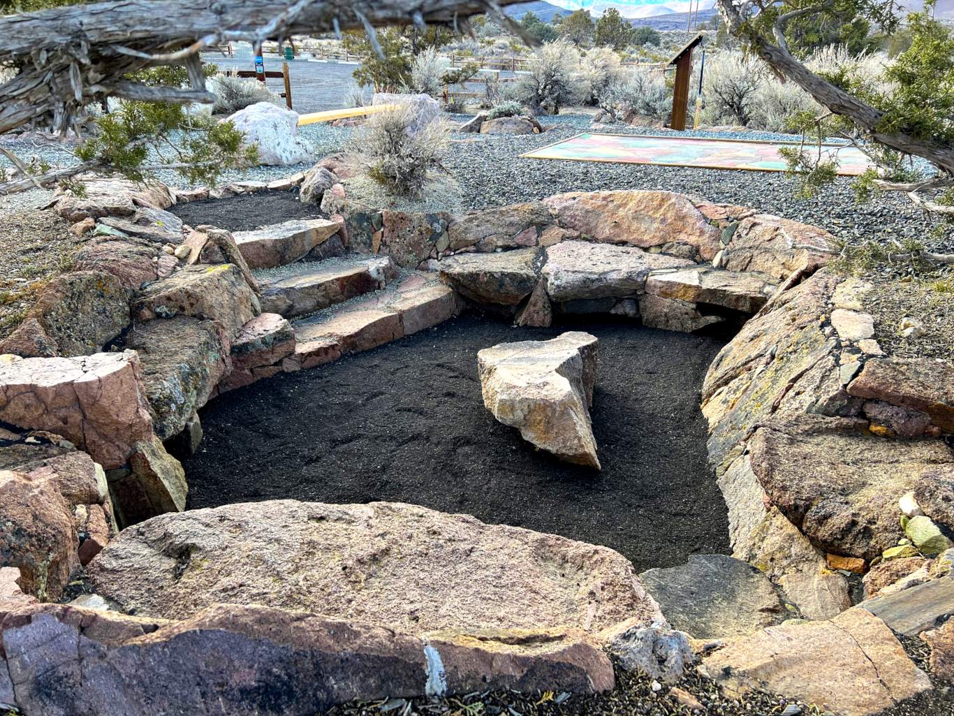 native rock seating area at teepad with live edge bench in background