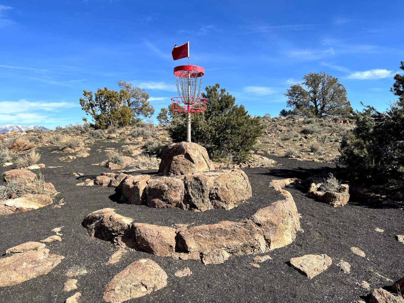 basket on top of constructed native rock pyramid surrounded by black cinder sand